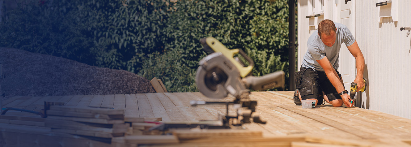 Man building deck in backyard.